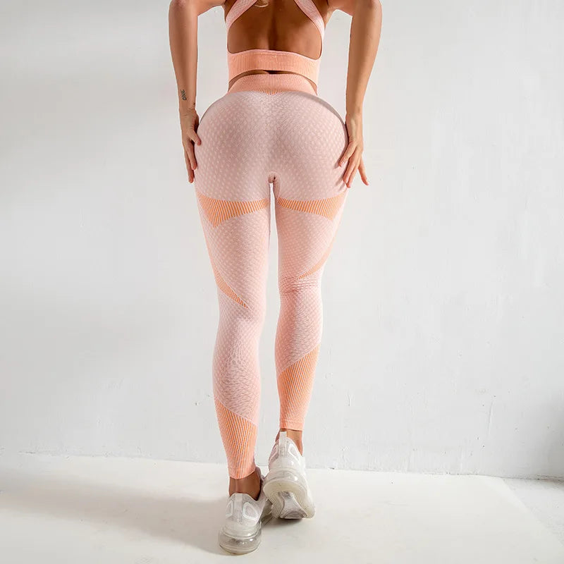 Person wearing pink athletic leggings and top on a white background